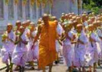 Group of young monks in white robes following their leader
